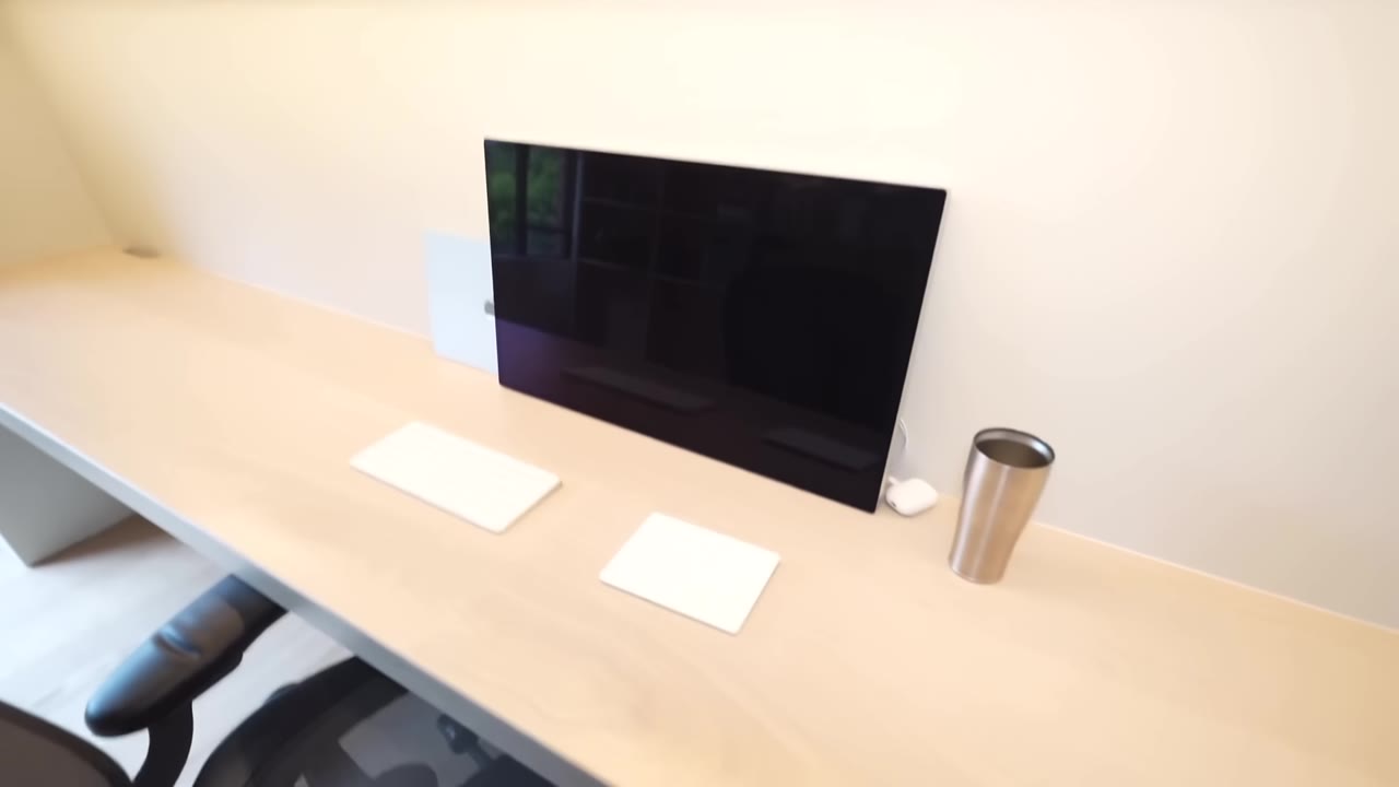 長い造作デスクにディスプレイとキーボードだけが置かれた書斎