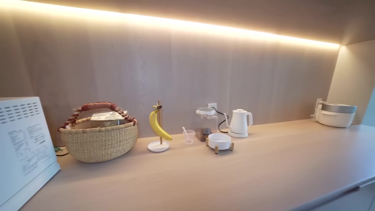 カウンターにトースター、ケトル、かご、バナナが並ぶキッチン