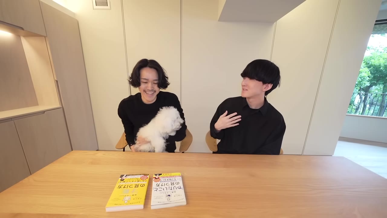 テーブルで身振りを交えて話す八木さんとしぶ。手前に著書2冊