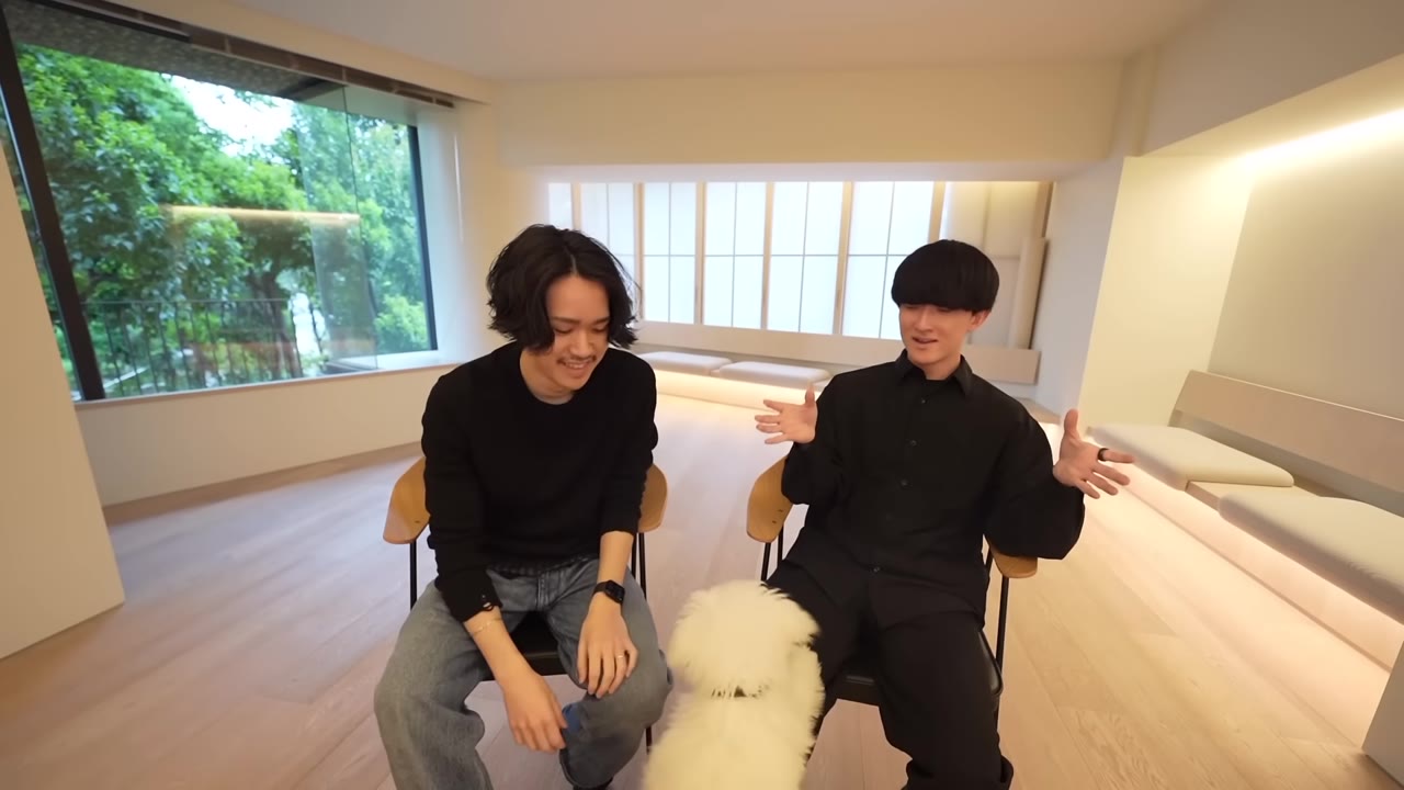 身振りを交えて話す八木さんと、足元の犬