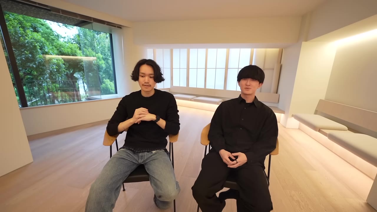 窓の外の緑を背にして座る2人